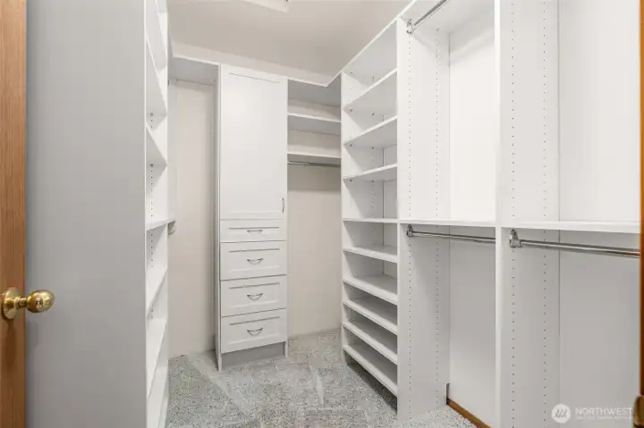 Primary walk in closet with system for the organized at heart.