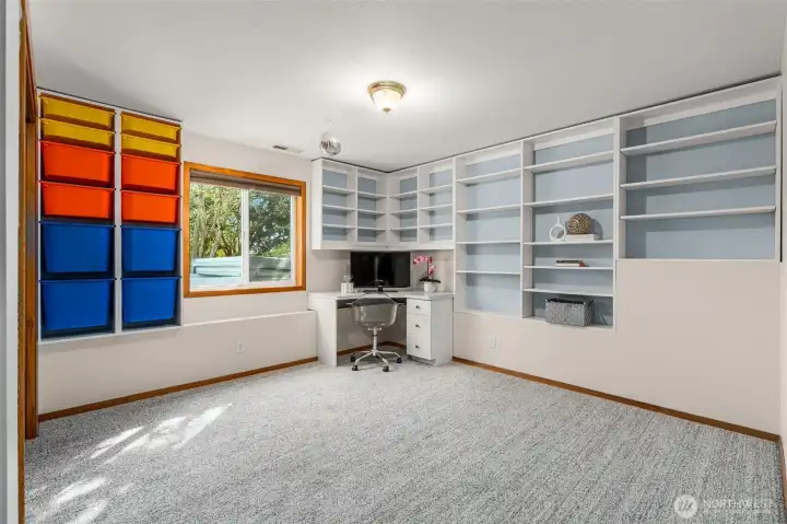 Third bedroom with built in storage bins and bookcase shelving.