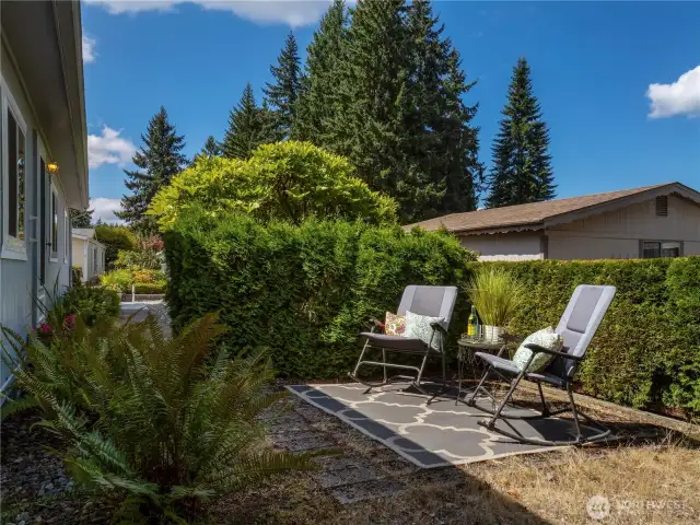 a private patio is located at the left side of the home and is privately shielded by clever landscaping.