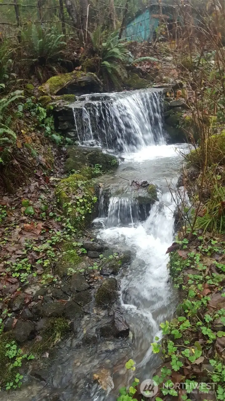 This is Fallingwater, built by landowner to disguise the mouth of a culvert that runs beneath the road. Many of the rocks used in construction were hauled down from areas above the town. Fallingwater comes alive in winter and spring.