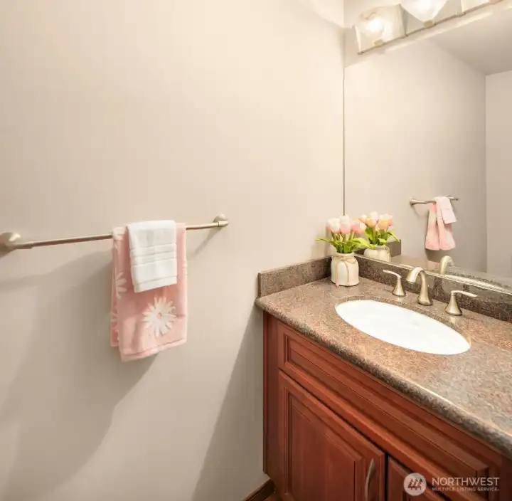 Power room features cherry vanity, granite countertop, and Kohler sink/toilet.
