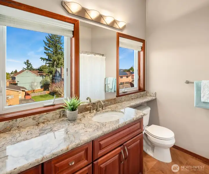 ADU Full Bath features double vanity, quarts countertop, Kohler sink/toilet, ceramic floor tile, and Milgard casement windows.