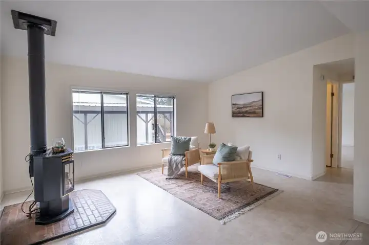 Enter the home from the front into the living room with large windows and a gas stove for year round comfort.