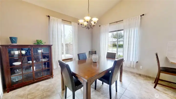 Spacious dining room with vaulted ceiling and tile flooring