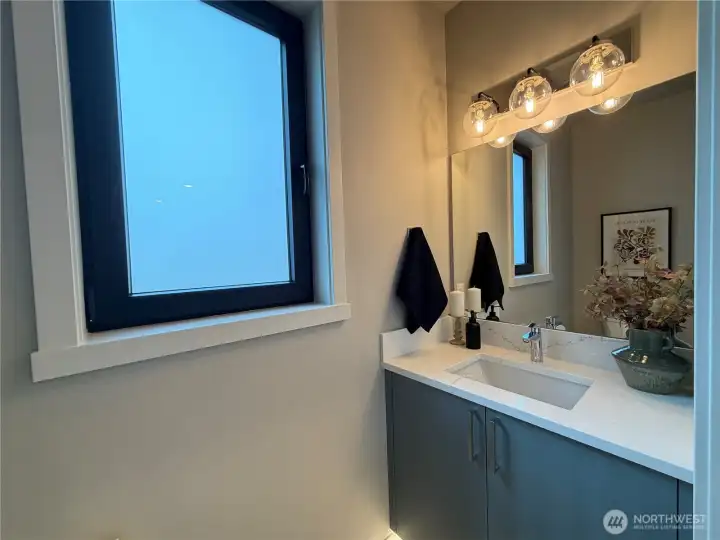 Main floor powder room with motion activated under cabinet lighting.