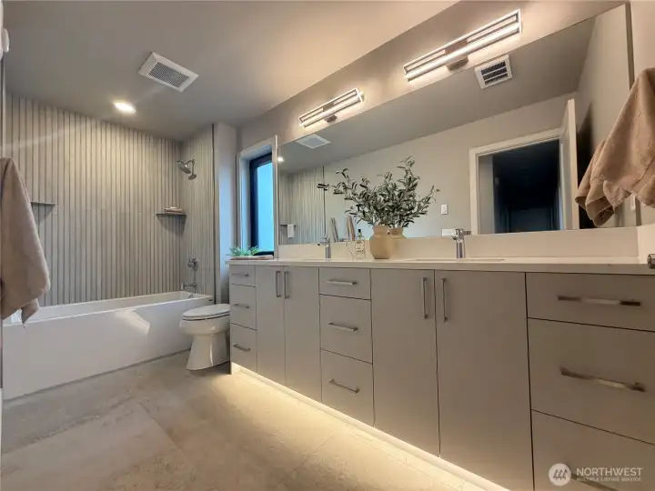 Guest bath with motion activated under cabinet lighting, and deep tub.
