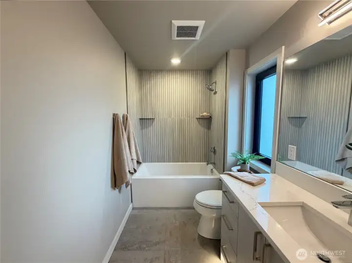 Guest bath with motion activated under cabinet lighting, and deep tub.