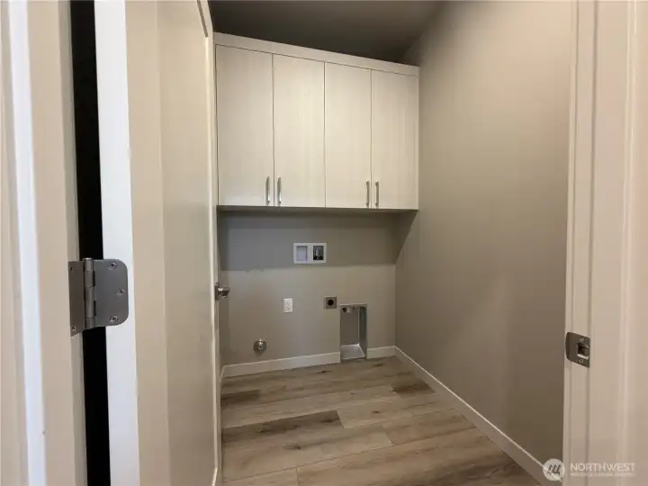 Upstairs utility room with cabinets and door.