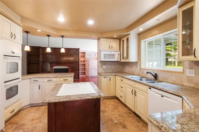 Updated kitchen with granite counters, tile backsplash, double oven, tons of cabinet space and eating bar is the perfect space for cooking and entertaining.