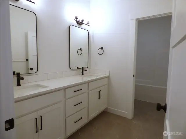 Hall bathroom has separate shower room and double sink vanity for auxiliary bedroom use.