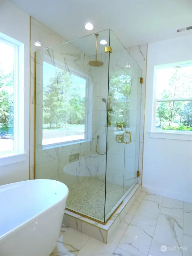 Large light and bright custom tile shower and separate soaking tub help to wash away the day.