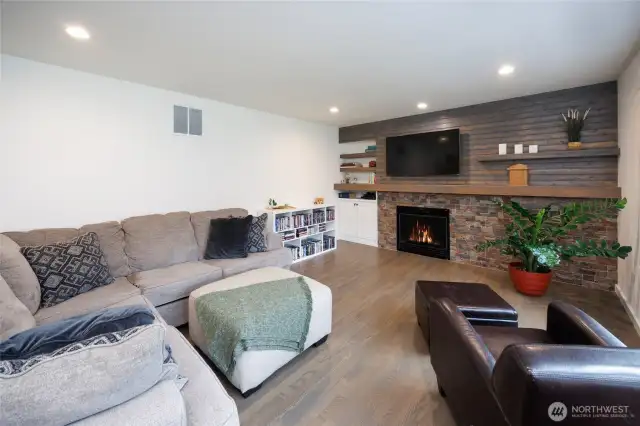 Family room has wall of windows and gas fireplace.