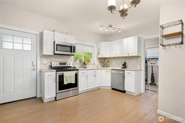 Open kitchen with stainless appliance, vinyl plank floors, open and tons of natural light