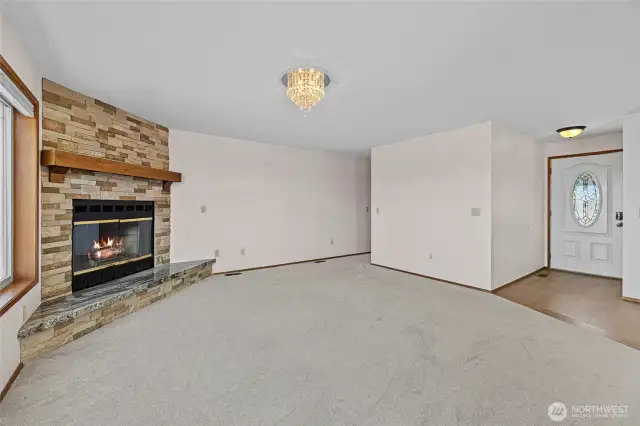Living room with view of the entry way and stone fireplace