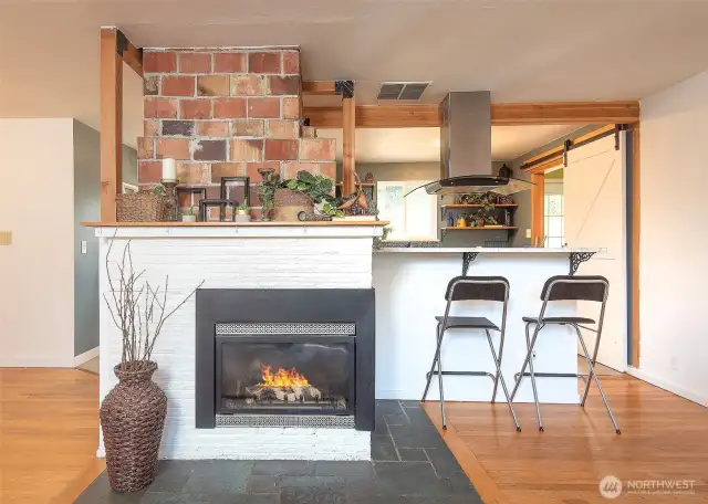 Gas fireplace and a kitchen with eating space.