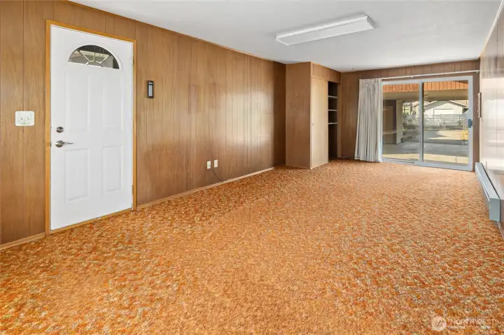 Man door leads to the side yard, sliding door in back leads to the carport.