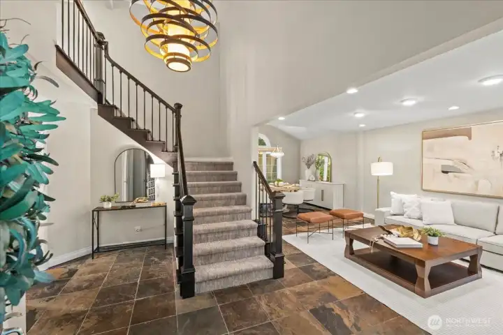 The dramatic two-story entrance with a beautiful modern light fixture welcomes you home.