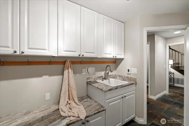 The mudroom is a perfect place to drop your shoes and backpacks, keep pet supplies, extra storage and to wash up after working in the garage. This space was previously the main floor laundry and the water lines are still in the wall should you want to move the laundry back downstairs. This space features the same resilient dolomite countertop material as in the kitchen.