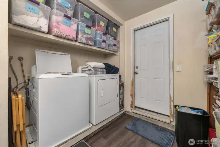 Unit 2 - Convenient in-unit laundry with full-size washer and dryer, built-in shelving for storage, and direct access to the exterior for easy daily living.