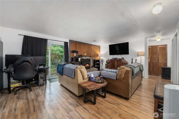 Unit 1 Living room view toward the main entry and hallway, highlighting additional storage access, updated flooring, and easy circulation throughout the home.