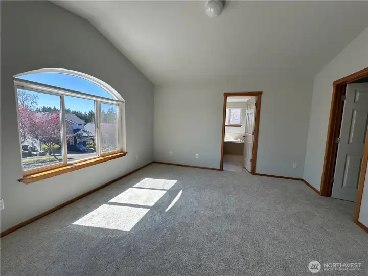 Pitched ceiling in master bath. Walk in closet on right and en-suite ahead. House faces south for morning and afternoon sun