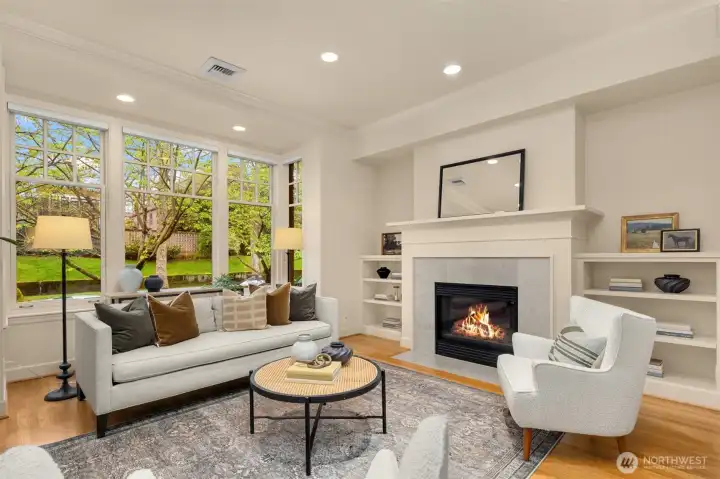 Cozy gas fireplace and classic woodwork including crown molding and shelving flanking the fireplace