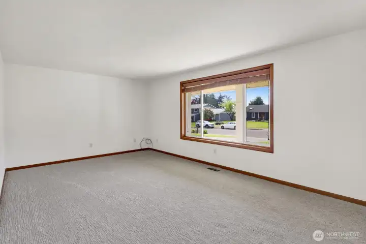 Enjoy the fresh feel of this inviting living room, featuring newly installed carpet and plenty of natural light from the south facing window for a warm, cozy atmosphere.