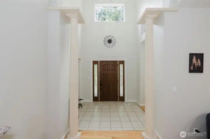 Grand foyer  with vaulted ceilings, tons of natural light and pillars framing the space.