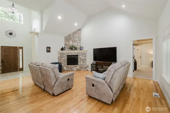 Living room boasts large fireplace with river rock surround.
