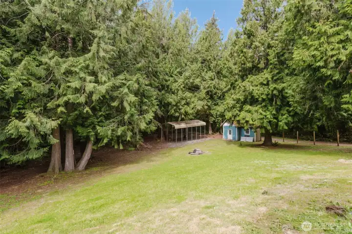 Backyard includes large shed and covered RV parking space.