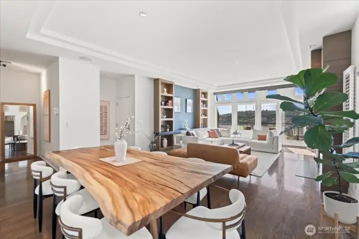 A stunning live-edge dining table anchors the room against a backdrop of sweeping city and lake vistas.