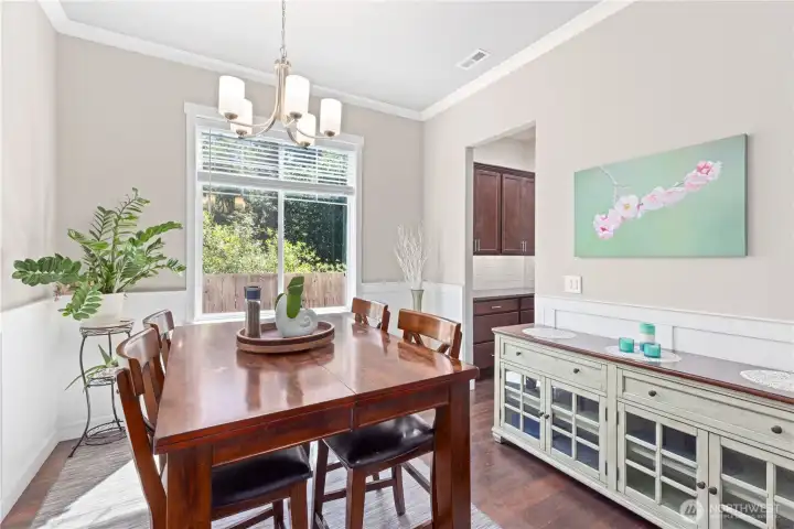 Formal dining room with great natural light, crown molding and wainscoting for a designer touch.