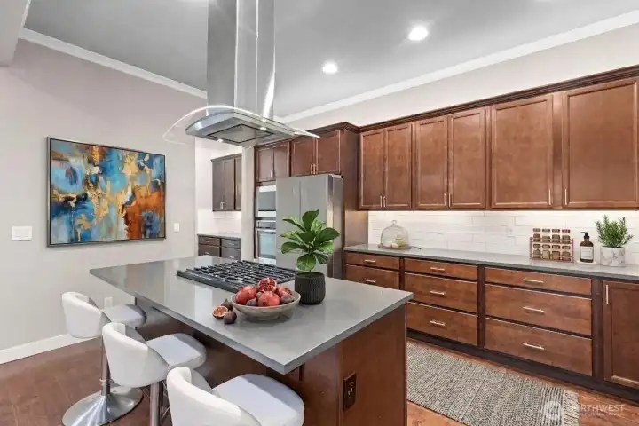 Stunning kitchen with SS appliances, overhead hood fan and handy island. Some decor is digitally staged.