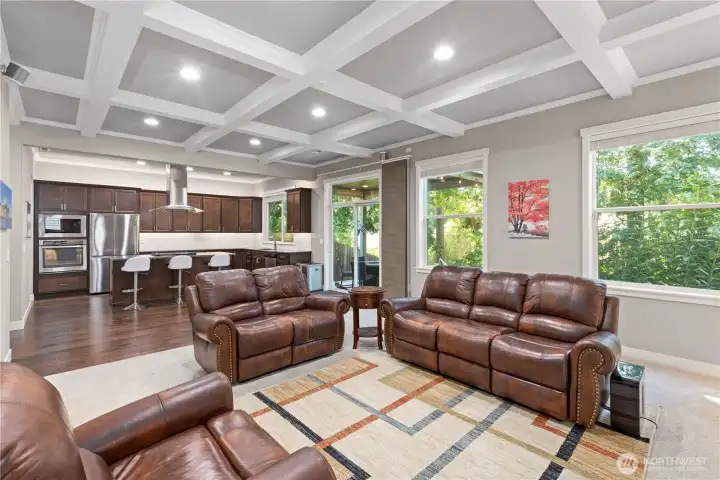 Open concept living and dining room with box beam ceiling detail.