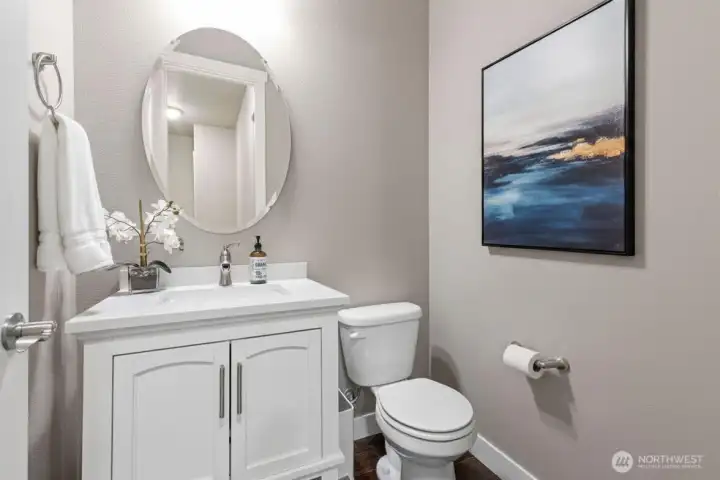 Half bath on main level. Art is digitally staged.