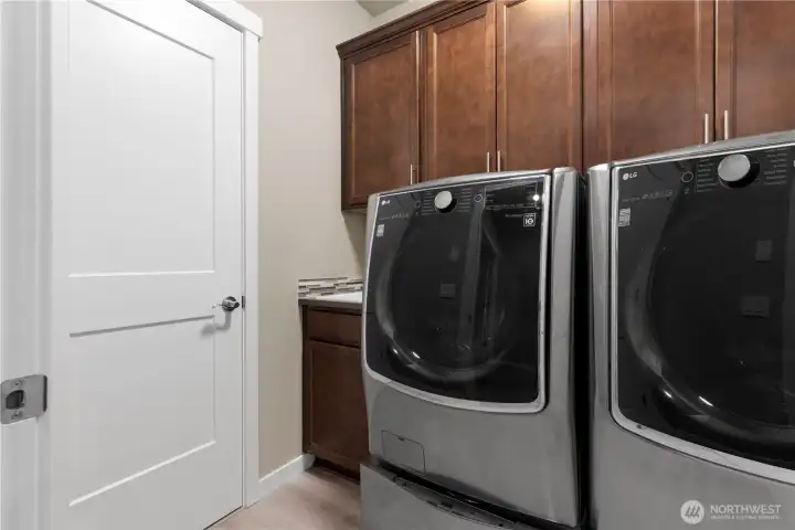 Laundry room, deep sink and large storage closet. The washer is actually a DUAL washer with second washer in the pedestal below. Both washer and dryer convey.
