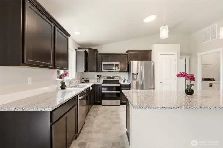 Easily accessible kitchen with slab granite counters