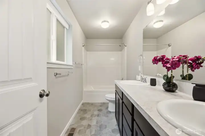 Primary bath with full tub, shower, and dual vanity