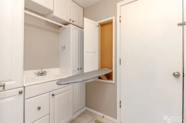 Washroom with sink, ironing board and a ton of additional cabinet space.  Washer and dryer are also in the washroom and they stay with the home