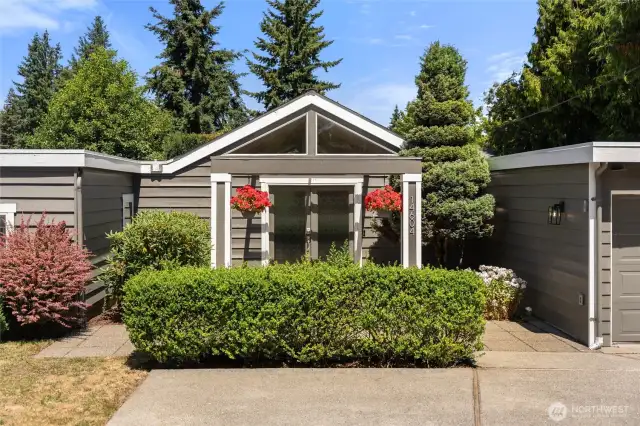 Private entry hidden by mature landscaping.