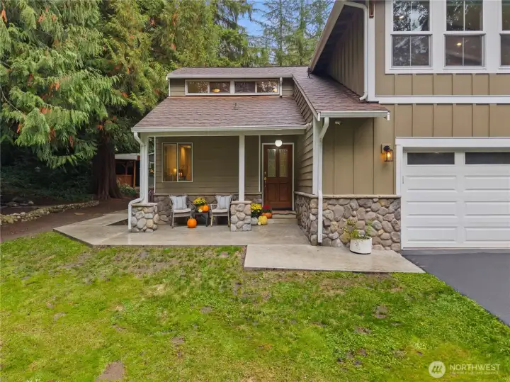 The entry of the home features a covered front porch and gives you a peak of the stamped concrete patio that wraps around to the back of the house - accessible by the front door, side French doors, and back French doors of the home.