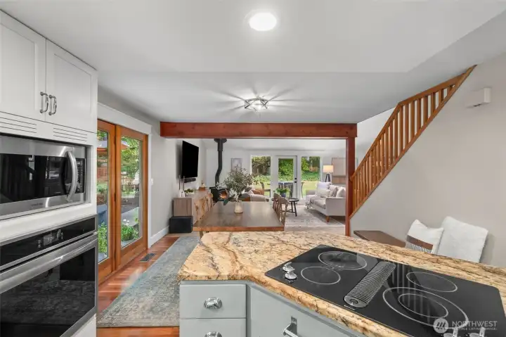 The kitchen looks out into the open floor plan, through the dining room and into the main living area.