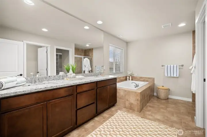 Primary en-suite with double vanity and soaking tub.