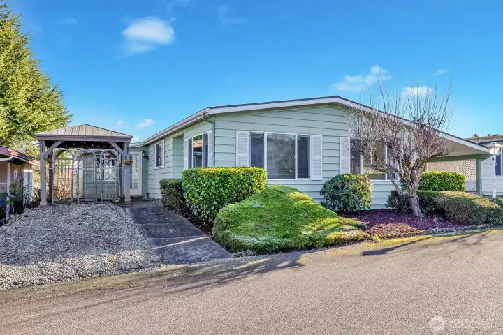 Street view of the formal entry into the home. "No Step" sidewalk from the street for walker access.  Rare parking area at the North side of the home.