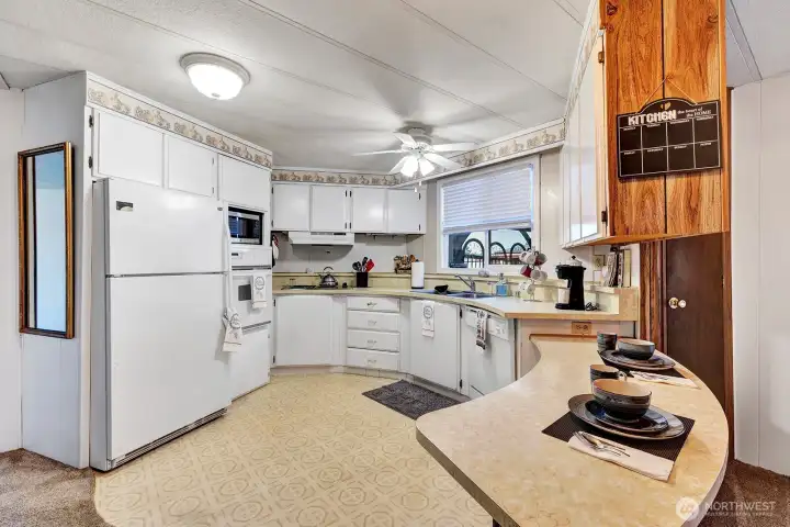 Circular style kitchen has some newer appliances. Plenty of storage space and meal prep areas. Ceiling fan and updated lighting for your convenience. Garden view window lets you look out toi the Gazebo area.