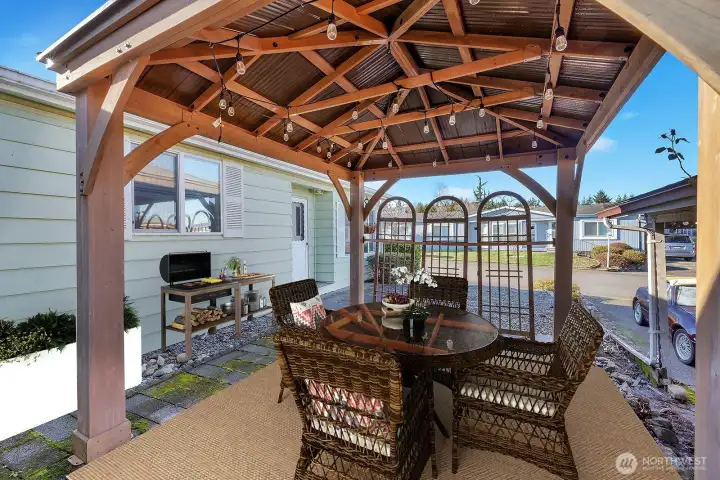 Gazebo area with lighting at the north end of the home. Great place to sit outside, covered from the weather elements and enjoy your morning coffee or an outdoor barbeque. Virtually Staged.