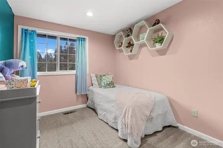 Located at the end of the upper floor, this cute secondary bedroom floods with natural light and offers a playful environment.
