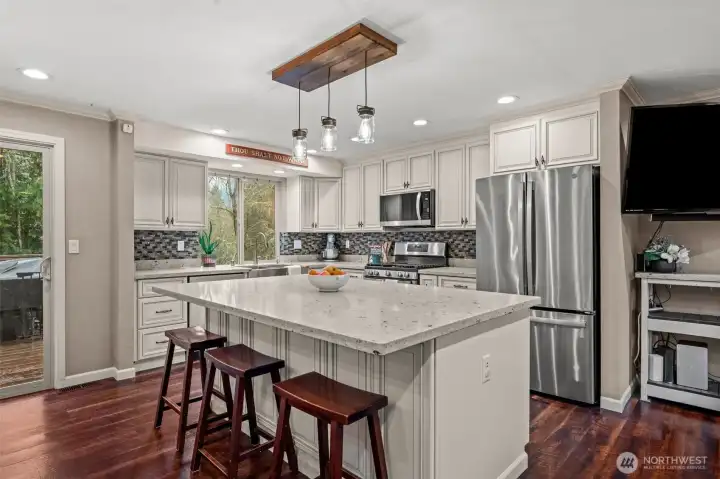 This modern farm-style kitchen accommodates storage with it's expansive cabinetry and ample countertop space.