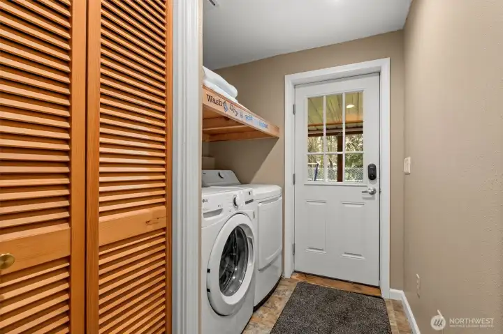With direct access to the outside covered patio and ample storage, this laundry room has it all!