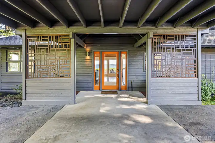 Carport and front entry flanked by custom iron panels